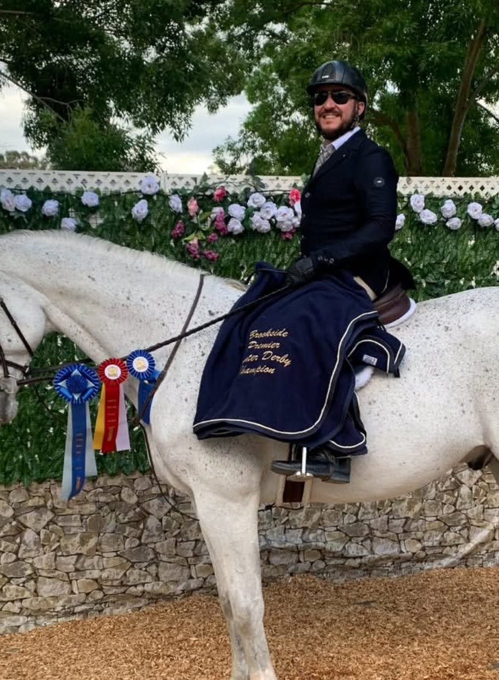 Ryan Oropeza in a navy show coat after a Brookside Premier Derby win, mounted on his Silver Gray, Rendezvous